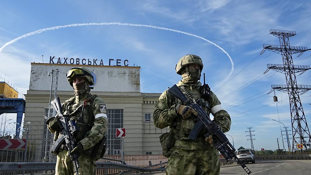 ARCHIV - Zwei russische Soldaten bewachen einen Eingang des Wasserkraftwerks Kachowka (Archivbild). Foto: Uncredited/AP/dpa