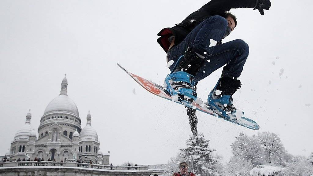 Snowboarden vor der Sacré-Coeur Basilika: Dieser Mann geniesst den Schnee in Paris offenbar.