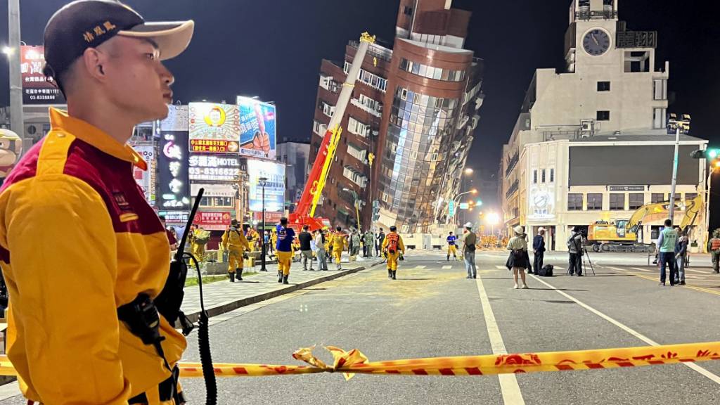 dpatopbilder - Ein Rettungshelfer steht in der Nähe der abgesperrten Stelle eines schiefen Gebäudes nach einem Erdbeben. Foto: Johnson Lai/AP/dpa