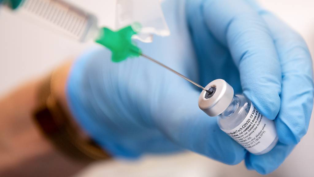 Eine Klinik-Mitarbeiterin zieht den Covid-19-Impfstoff von Biontech/Pfizer für eine Impfung auf eine Spritze.