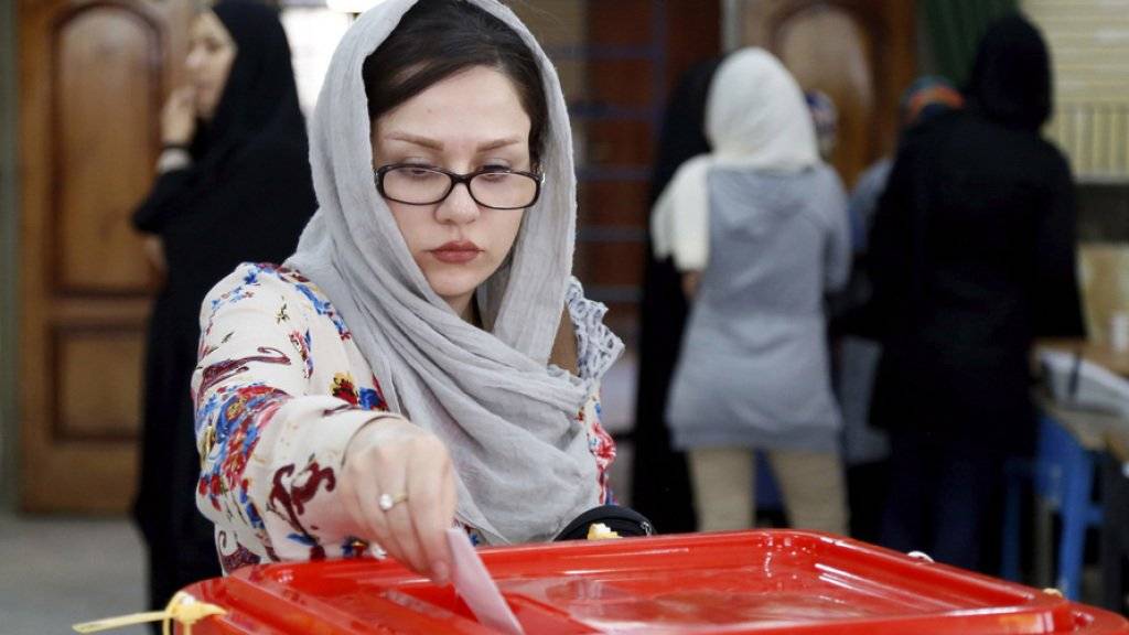 Eine Iranerin steckt ihren Wahlzettel in eine Urne. Die zweite Runde der Parlamentswahl im Iran war ein Erfolg für Reformer und Moderate.