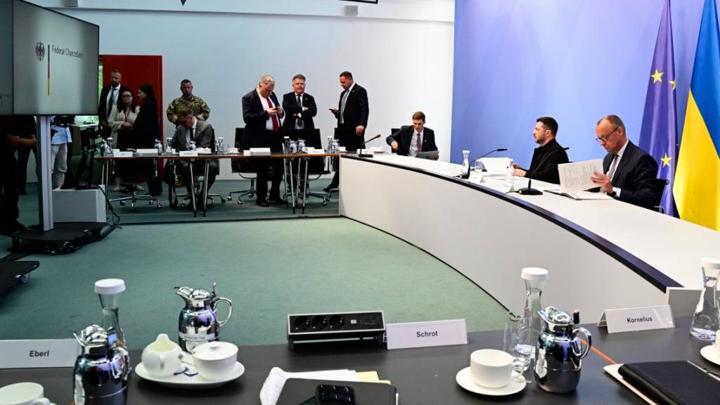 Wolodymyr Selenskyj (2.v.r), Präsident der Ukraine, und Bundeskanzler Friedrich Merz (CDU, r) warten im Kanzleramt auf den Beginn von virtuellen Beratungen europäischer Staats- und Regierungschefs mit Blick auf das Treffen von US-Präsident Trump und dem russischen Präsidenten Putin. Foto: John Macdougall/AFP Pool/dpa