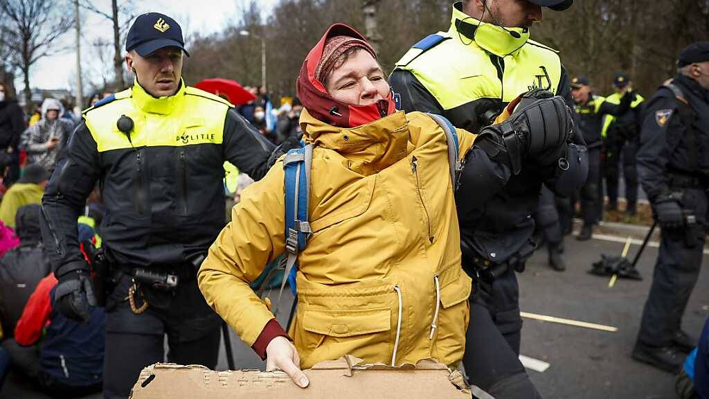 Klimaaktivisten von Extinction Rebellion werden während einer Blockade auf der Utrechtsebaan von Polizisten davon getragen. Foto: Sem Van Der Wal/ANP/dpa