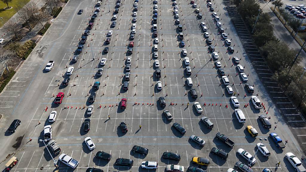 ARCHIV - Autos stehen auf einem Parkplatz in Houston Schlange - die Insaßen warten darauf, gegen das Coronavirus geimpft zu werden. Foto: Mark Mulligan/Houston Chronicle/AP/dpa - ACHTUNG: Nur zur redaktionellen Verwendung und nur mit vollständiger Nennung des vorstehenden Credits