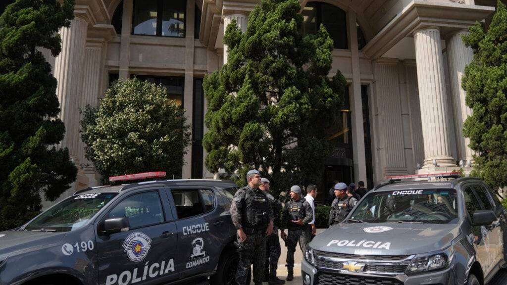 Polizisten stehen vor einem Gebäude in der Avenida Faria Lima in Sao Paulo während eines Einsatzes zur Untersuchung von Investmentfonds und des Kraftstoffsektors. In Brasilien hat eine landesweite Razzia einen milliardenschweren Betrugs- und Manipulationsskandal im Kraftstoffsektor aufgedeckt. Foto: Andre Penner/AP/dpa