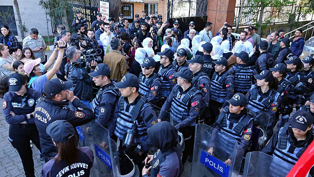 Eingekreist von Polizeibeamten protestieren Menschen gegen den nachträgliche Ausschluss des gewählten prokurdischen Bürgermeisters in der Stadt Van in der Türkei. Foto: Mehmet Masum Suer/SOPA Images via ZUMA Press Wire/dpa