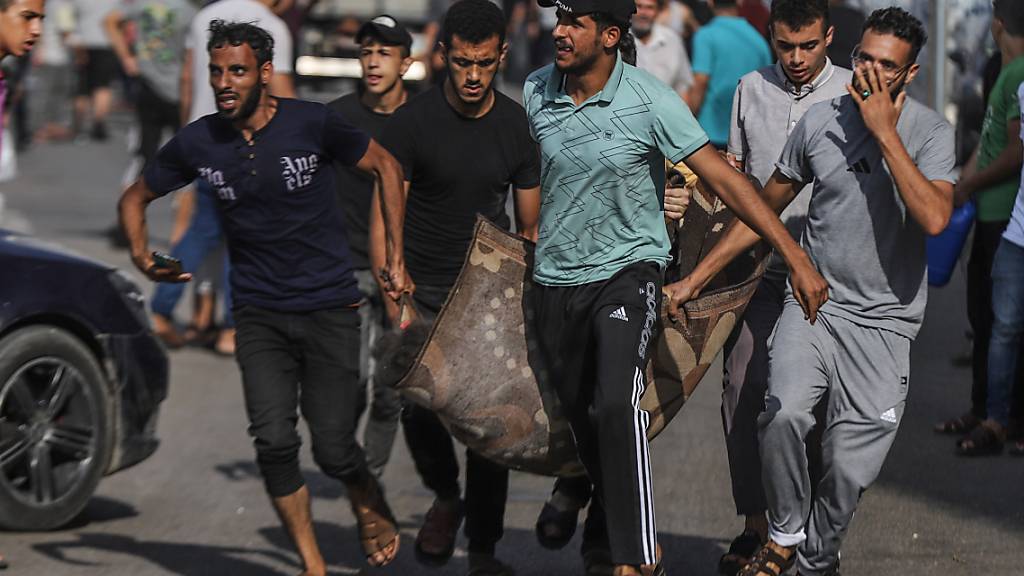 Palästinenser tragen eine verletzte Person nach einem israelischen Luftangriff auf ein Gebäude in Gaza. Foto: Mohammed Abu Elsebah/dpa