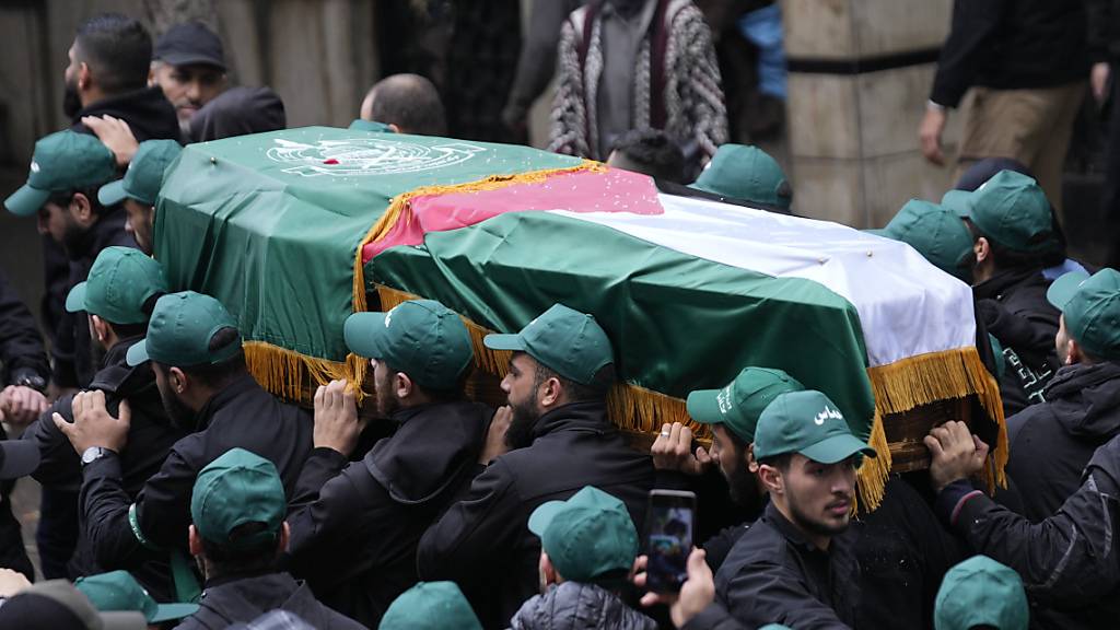 Hamas-Mitglieder tragen den Sarg von Mohammed al-Rayess, der zusammen mit Saleh Arouri, einem der obersten Hamas-Befehlshaber im Ausland, bei einer Explosion am 02.01.2024 in Beirut getötet wurde, während ihres Trauerzuges. Foto: Hussein Malla/AP/dpa