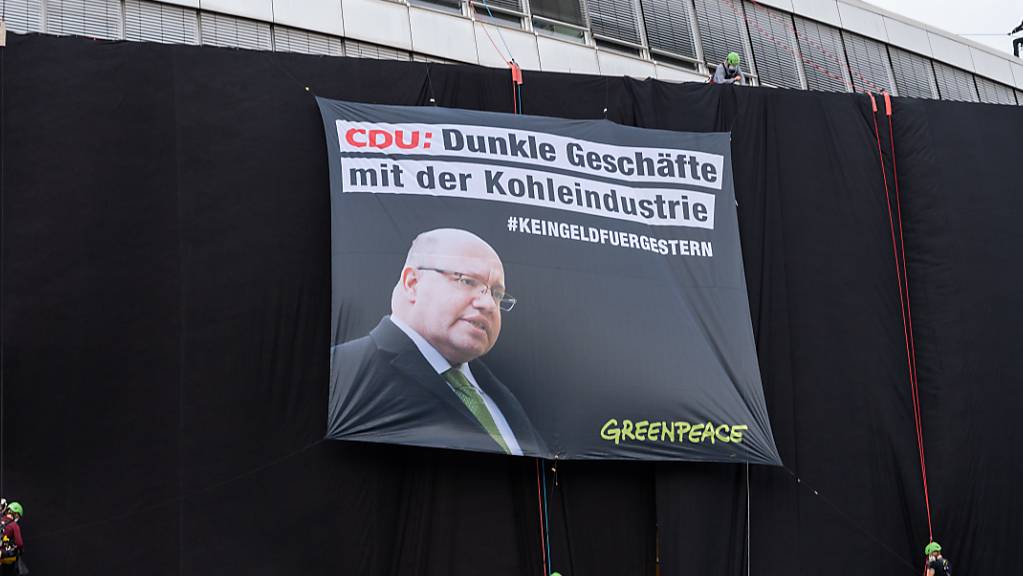 Greenpeace-Aktivisten haben die Parteizentrale der CDU mit schwarzem Stoff verhüllt. Foto: Christophe Gateau/dpa
