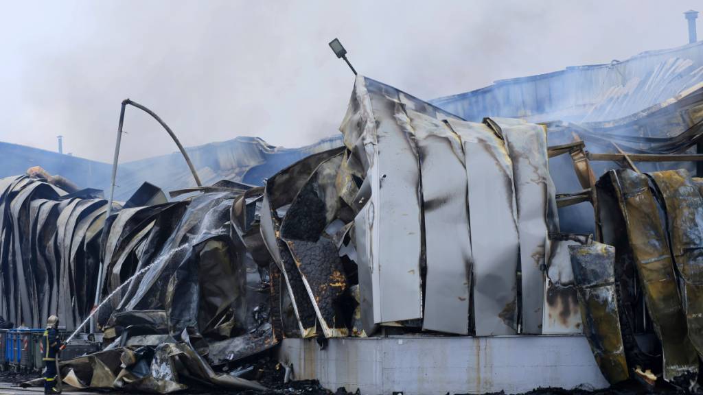 dpatopbilder - Ein Feuerwehrmann versprüht Wasser nach einer Explosion und einem Brand in einer Keksfabrik in Trikala. Foto: George Kidonas/InTime News/AP/dpa