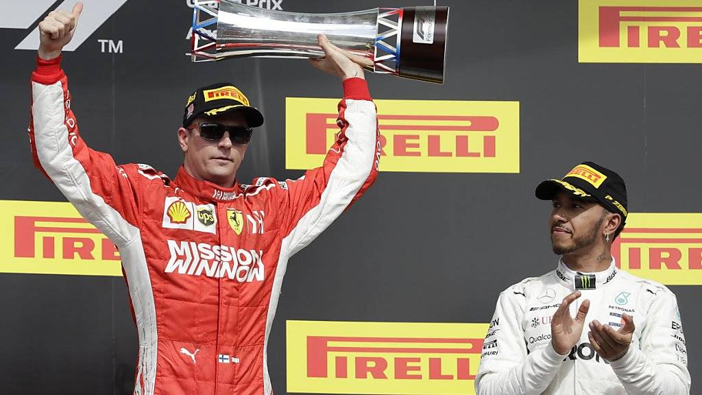 Kimi Räikkönen mit Siegerpokal, Lewis Hamilton applaudiert artig