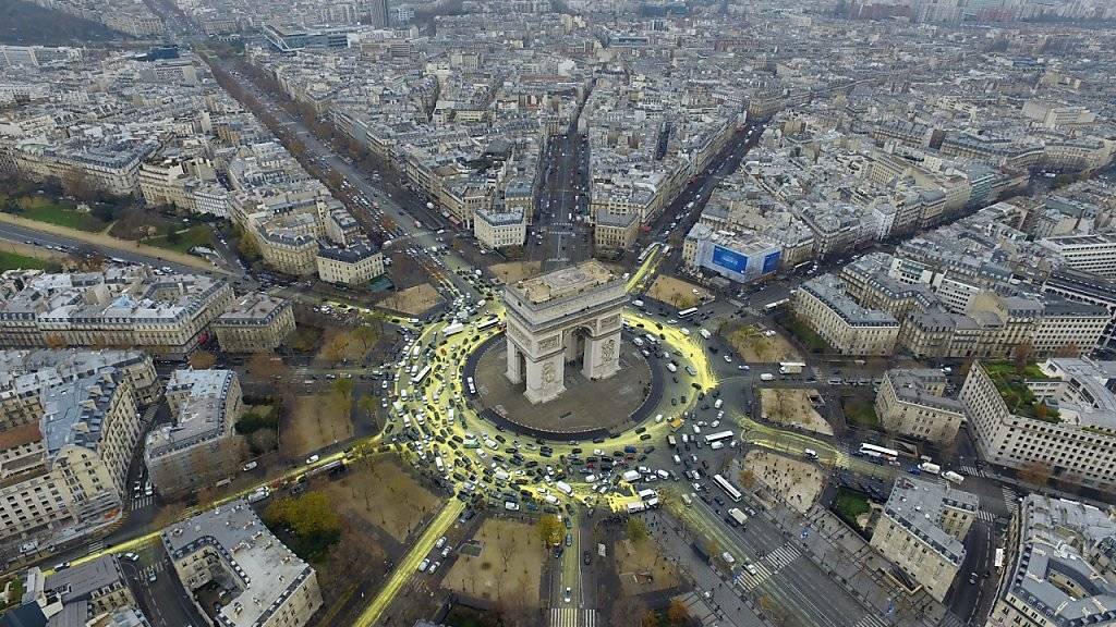 Von Greenpeace-Aktivisten gelb gefärbter Kreis, die Sonne symbolisierend, rund um den Triumphbogen im Herzen von Paris