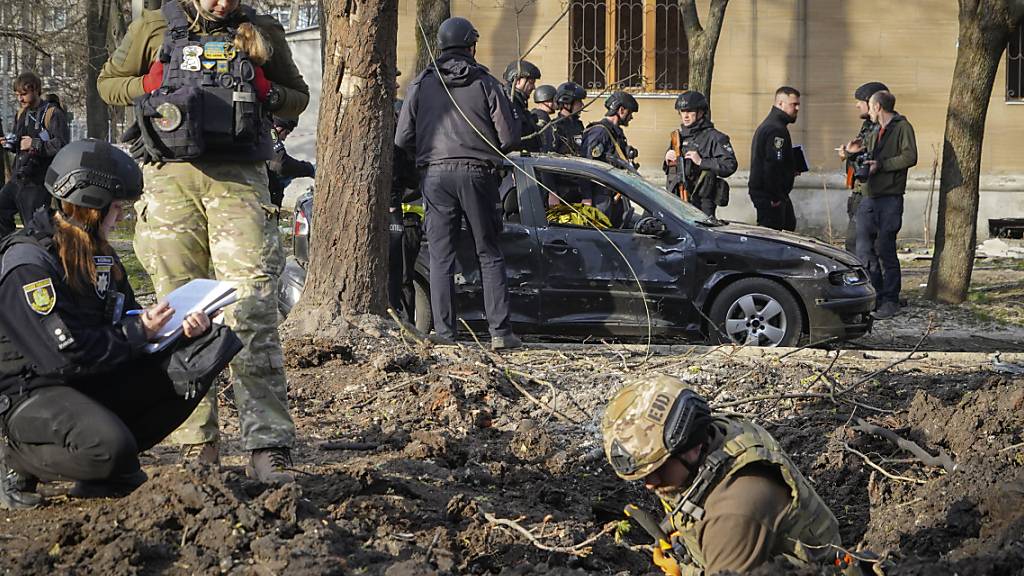 dpatopbilder - Militärexperten untersuchen den Ort eines russischen Bombenangriffs, bei dem mehrere Menschen getötet wurden. Foto: Andrii Marienko/AP/dpa