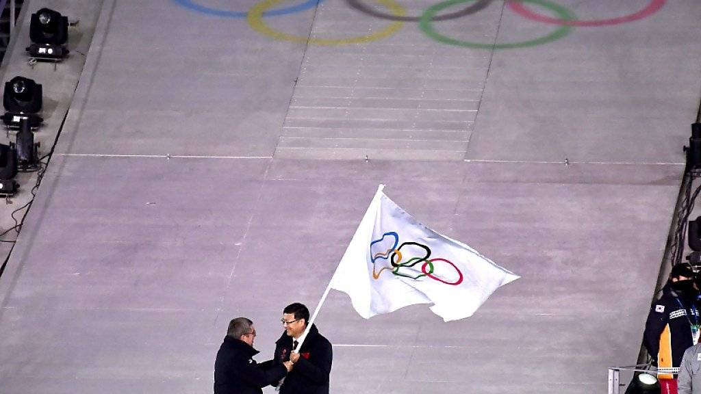 IOC-Präsident Thomas Bach überreicht die olympische Flagge an den Bürgermeister von Peking, Ausrichter der nächsten Winterspiele in vier Jahren