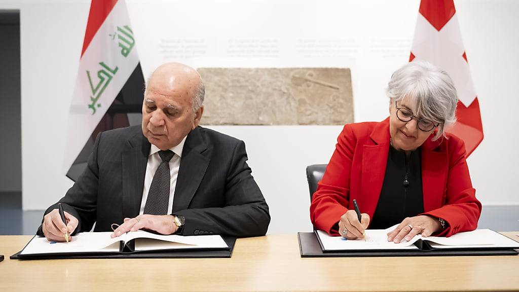 Iraks stellvertretender Premierminister und Aussenminister Fuad Hussein und Bundesrätin Elisabeth Baume-Schneider bei der Rückgabe von Kulturgütern an Irak. Im Hintergrund eines der an Irak zurückgegebenen Reliefs.