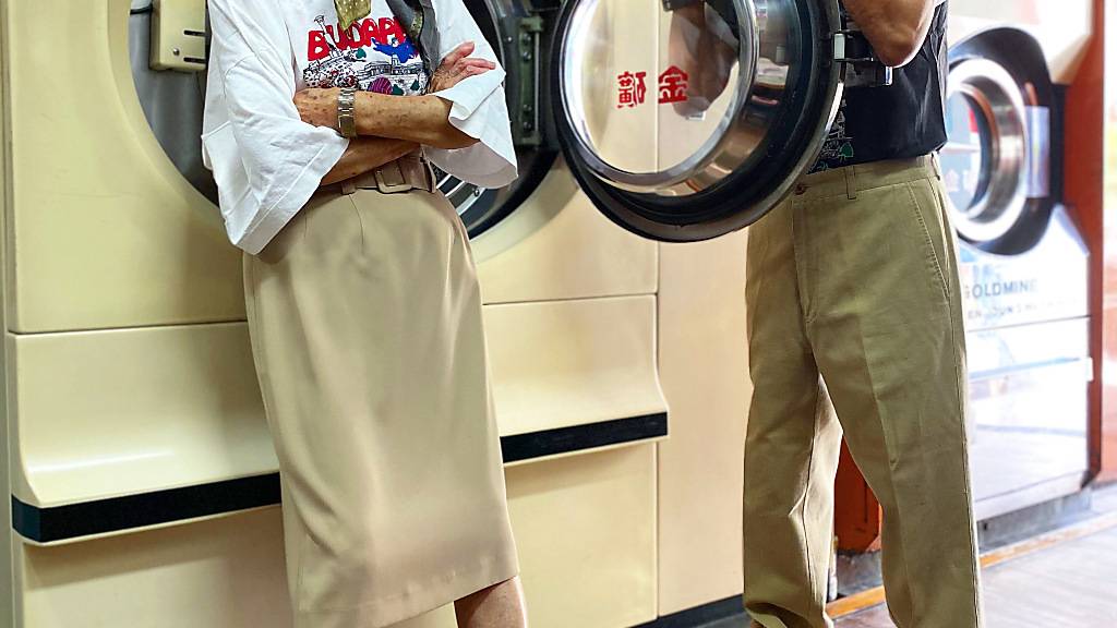 HANDOUT - Die 84 Jahre alte Hsu Hsiu-e und ihr 83 Jahre alter Mann Chang Wan-ji posieren in ihrer Wäscherei in Kleidung, die Kunden bei ihnen vergessen haben. Foto: Reef Chang/dpa - ACHTUNG: Nur zur redaktionellen Verwendung im Zusammenhang mit der aktuellen Berichterstattung und nur mit vollständiger Nennung des vorstehenden Credits