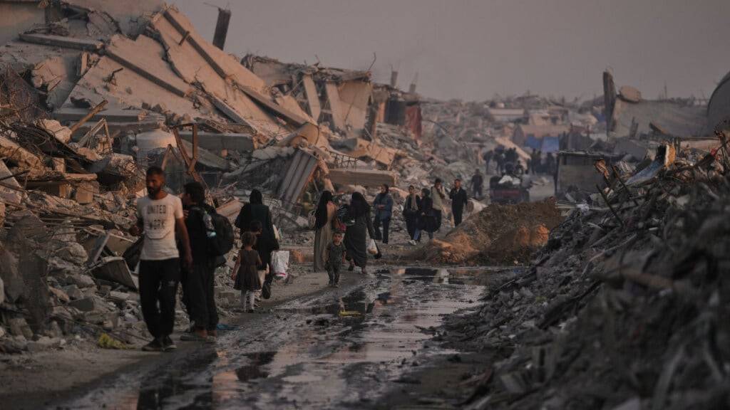 ARCHIV - Palästinenser gehen durch die Ruinen, die die israelische Luft- und Bodenoffensive in der Stadt Gaza hinterlassen hat. Foto: Jehad Alshrafi/AP/dpa