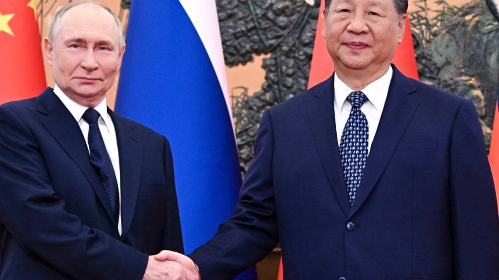 Der russische Präsident Wladimir Putin (l) und der chinesische Präsident Xi Jinping geben sich vor ihrem Treffen in der Großen Halle des Volkes die Hand. Foto: Sergei Bobylev/Pool Sputnik Kremlin/AP/dpa - ACHTUNG: Nur zur redaktionellen Verwendung und nur mit vollständiger Nennung des vorstehenden Credits