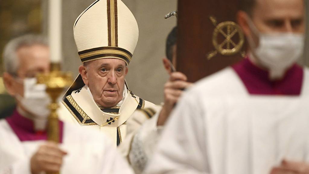 Papst Franziskus (m.) kommt in die Basilika Sankt Peter, um die Christmette zu feiern. Foto: Vincenzo Pinto/AFP POOL/AP/dpa