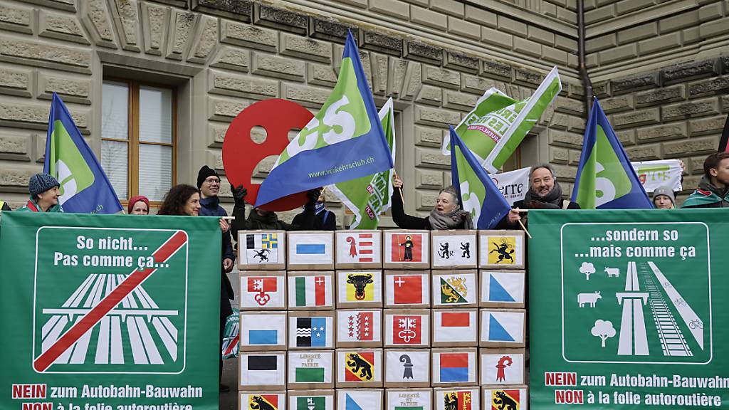 Komitee-Mitglieder und Unterstützer posieren bei der Einreichung der Unterschriften für das Referendum «Stopp Autobahn-Bauwahn, Nein zum masslosen Autobahn-Ausbau» am Donnerstag in Bern. (KEYSTONE/Peter Klaunzer)