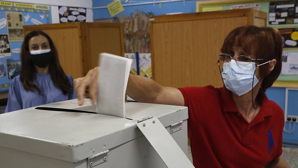 Eine Frau mit Mund-Nasen-Schutz gibt ihre Stimme in einem Wahllokal während der Parlamentswahlen ab.