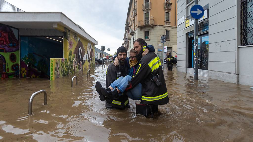 Rettungskräfte tragen eine Frau, nachdem der Fluss Seveso über die Ufer getreten ist. Foto: Stefano Porta/LaPresse via ZUMA Press/dpa
