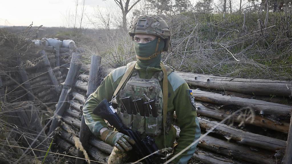 Ein bewaffneter ukrainischer Soldat trägt Militärkleidung und befindet sich in einer Kampfstellungen an der Trennlinie zum pro-russischen Separatistengebiet. Angesichts von Truppenaufmärschen auf russischem und ukrainischem Gebiet nahe dem Konfliktgebiet wächst die Sorge vor einer Eskalation.