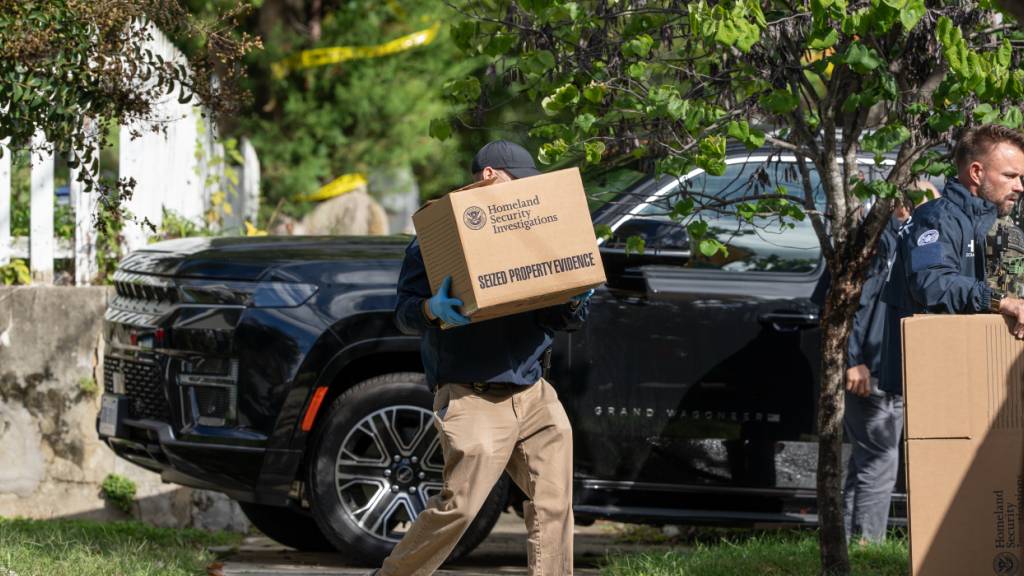 Beamte des Ministeriums für Innere Sicherheit tragen während einer Durchsuchung Kisten aus der Wohnung der linken US-Abgeordneten Omar. Foto: J. Scott Applewhite/AP/dpa