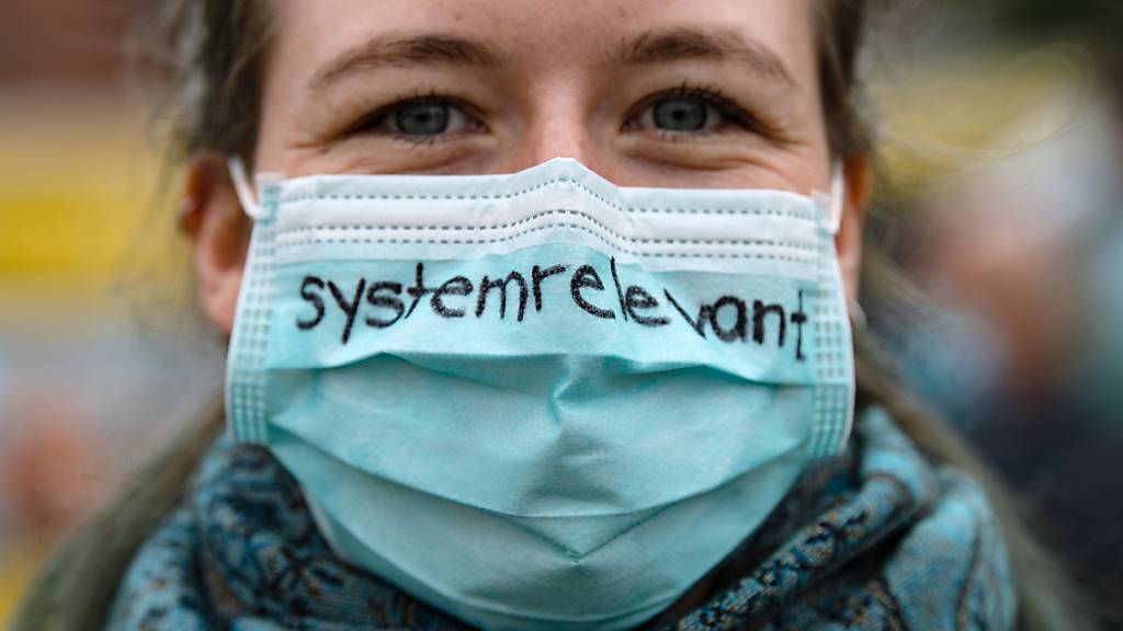 Keine Maskensünderin: Eine Krankenschwester trägt einen Mund-Nasenschutz mit der Aufschrift «systemrelevant» - dem Deutschschweizer Wort des Jahres 2020. (Archivbild)