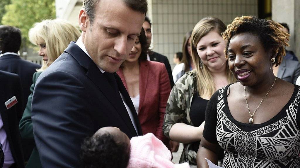 Frankreichs Präsident Emmanuel Macron hält ein Neugeborenes während eines Besuchs in einem Pariser Kinderspital (Archiv)