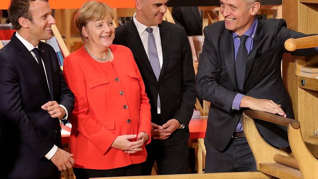 Frankreichs Präsident Emmanuel Macron, Bundeskanzlerin Angela Merkel und Bundesrat Alain Berset (von links) lassen sich an der Eröffnung der Buchmesse in Frankfurt erklären, wie die Gutenberg-Buchpresse funktionierte.