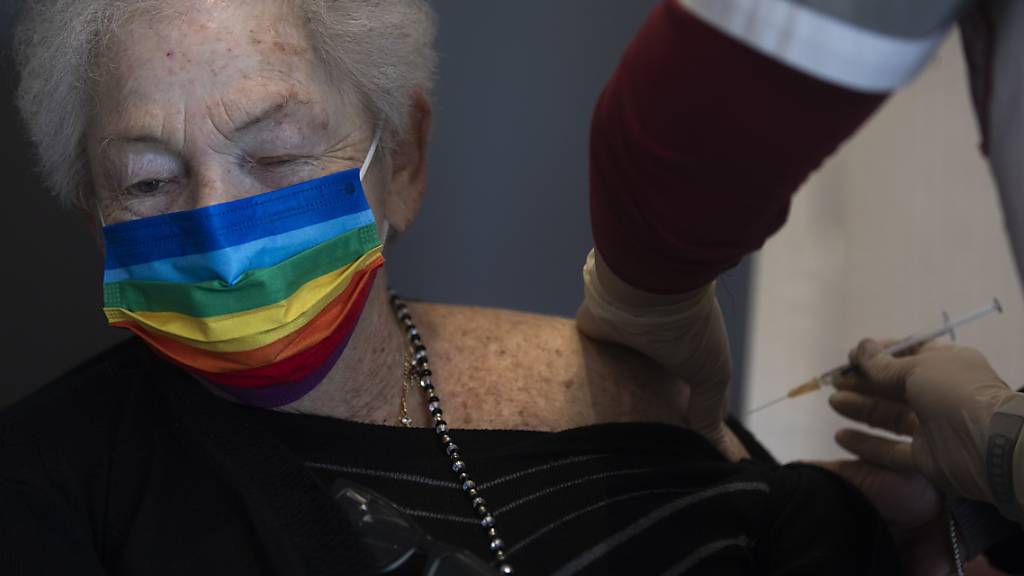 dpatopbilder - Eine israelische Frau bekommt in einem Pflegeheim von einem Freiwilligen der nationalen Hilfsorganisation «Magen David Adom» ihre zweite Impfdosis mit dem Corona-Impfstoff von Biontech/Pfizer. Foto: Oded Balilty/AP/dpa