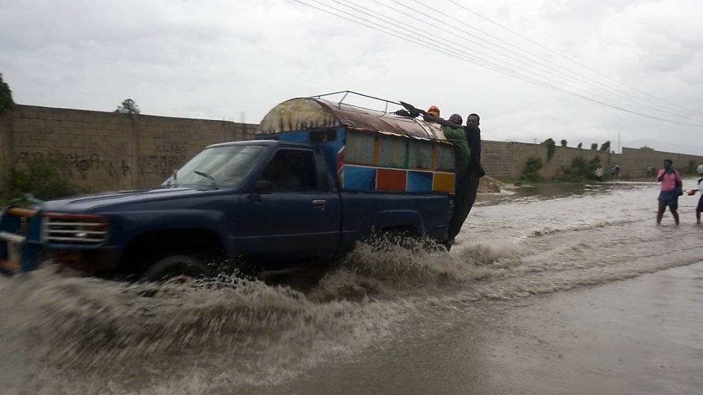 Ein Auto fährt durch eine überflutete Strasse in Port-au-Prince, der Hauptstadt von Haiti.