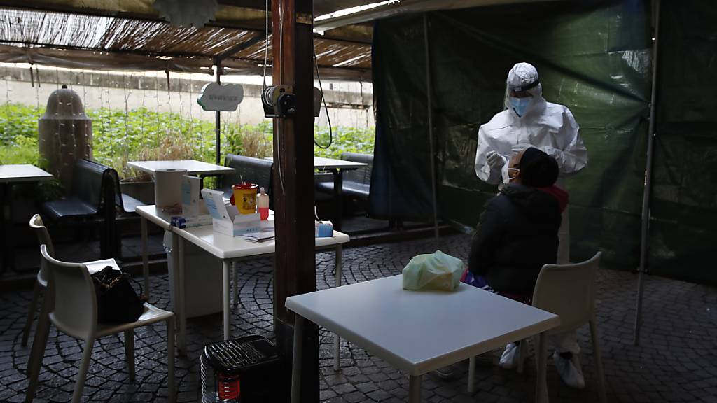 Eine Frau wird im Außenbereich eines geschlossenen Restaurants auf das Coronavirus getestet. Foto: Alessandra Tarantino/AP/dpa