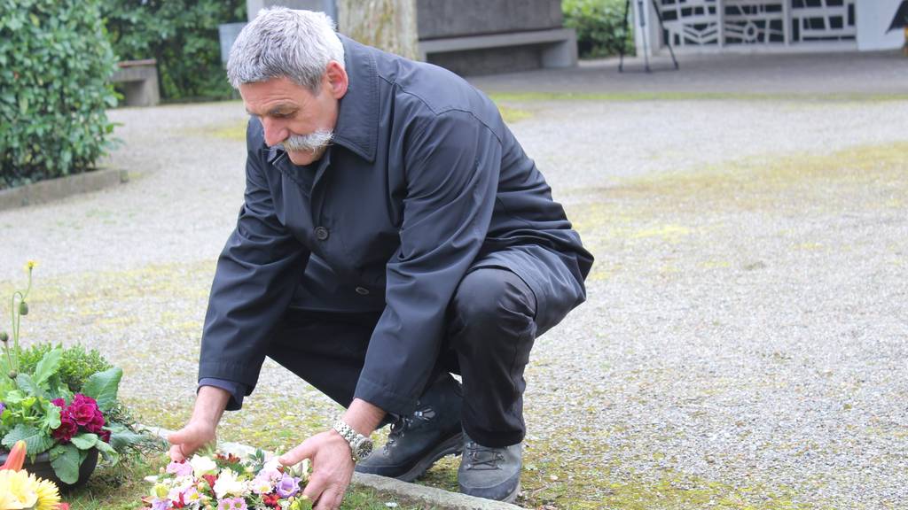 Herbert Nafzger platziert einen Blumenstrauss. (Bild: Lara Abderhalden)