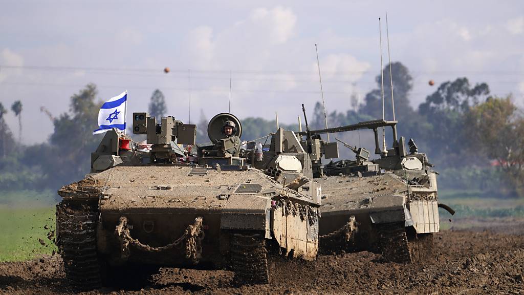 Israelische Soldaten fahren in ihren gepanzerten Fahrzeugen im Süden Israels nahe der Grenze zum Gazastreifen. Foto: Tsafrir Abayov/AP/dpa