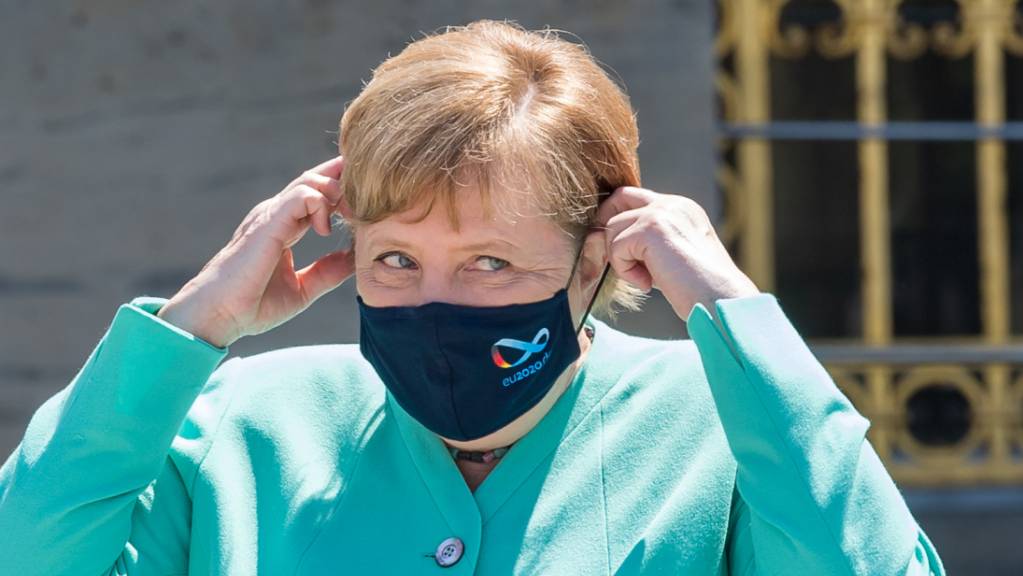 Bundeskanzlerin Angela Merkel (CDU) setzt sich vor Beginn der bayerischen Kabinettssitzung auf der Insel Herrenchiemsee ihre Mund-Nase-Schutzmasken auf. Foto: Peter Kneffel/dpa/Pool/dpa