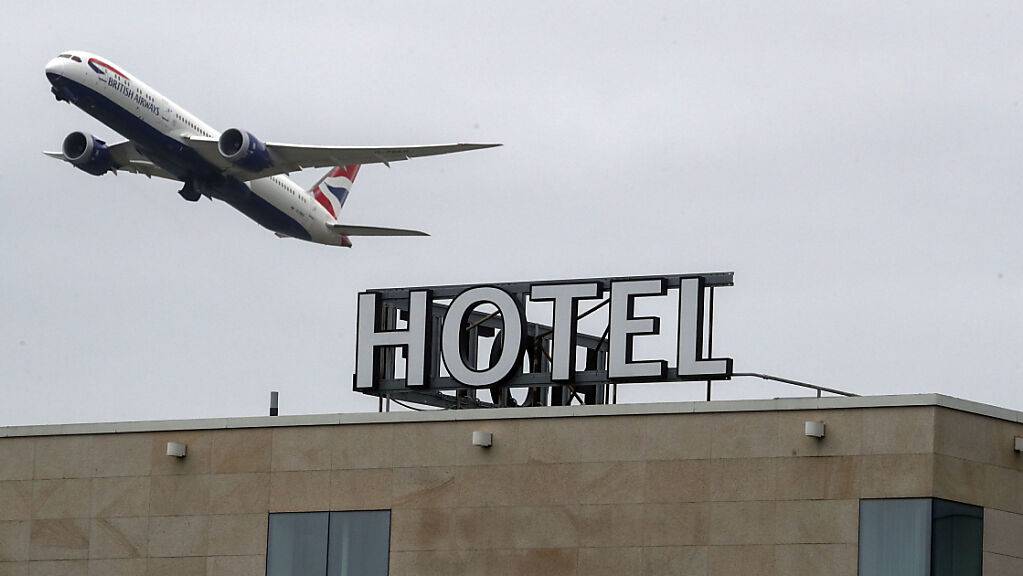 Ein Flugzeug fliegt über einem Hotel in London vorbei.