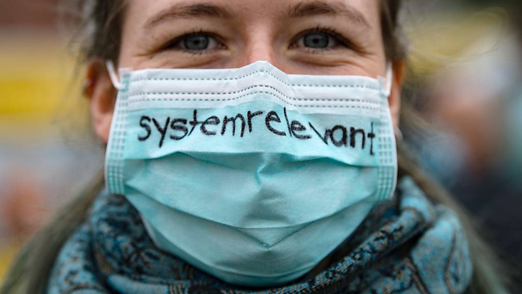Keine Maskensünderin: Eine Krankenschwester trägt einen Mund-Nasenschutz mit der Aufschrift «systemrelevant» - dem Deutschschweizer Wort des Jahres 2020. (Archivbild)