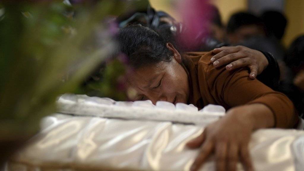 Eine Frau trauert während eines Trauergottesdienstes am Sarg ihres beim Brand im Heim in der Ortschaft San José Pinula nahe Guatemala-Stadt gestorbenen Kindes.