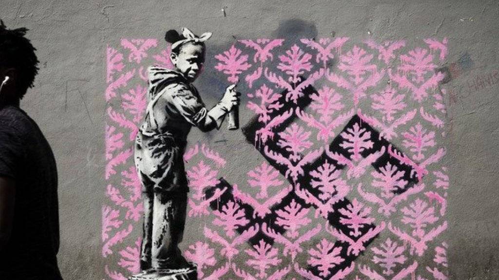 Auf Twitter wird gejubelt: Banksy ist zum ersten Mal in Paris! Bisher sind in der französischen Hauptstadt sechs mutmassliche Motive des Inkognito-Künstlers aufgetaucht. Hier ein Flüchtlingsmädchen, das ein Hakenkreuz mit einem rosa Blumenmuster übersprayt. (Twitter)