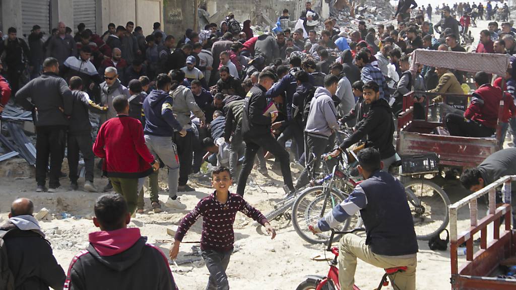 Palästinenser holen humanitäre Hilfe, die von der US-Luftwaffe im Gazastreifen abgeworfen worden ist. Foto: Mahmoud Essa/AP/dpa