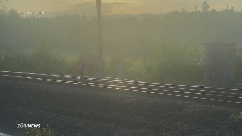 Bub steht barfuss auf dem Gleis