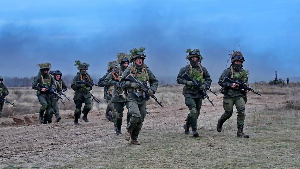 Bewaffnete und getarnte ukrainische Soldaten durchqueren ein Feld bei Stare. Foto: -/Ukrinform/dpa