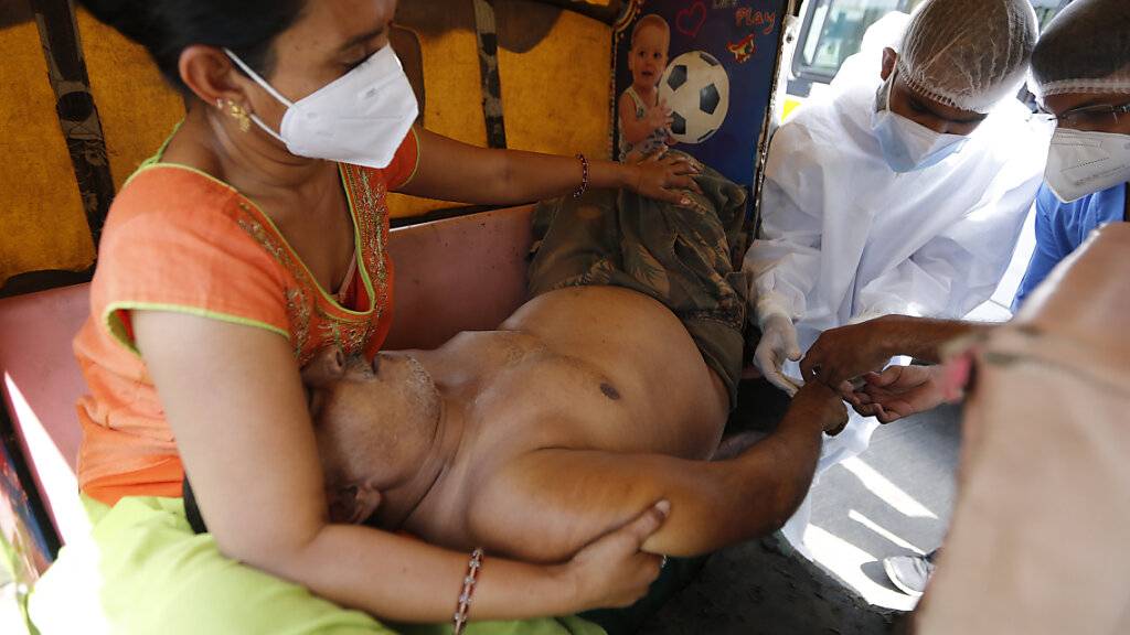 Ein COVID-19-Patient wird in einem Fahrzeug im COVID-19-Regierungskrankenhaus versorgt. Ein Feuer tötete 13 COVID-19-Patienten in einem Krankenhaus im Westen Indiens am 23.04.2021. Foto: Ajit Solanki/AP/dpa