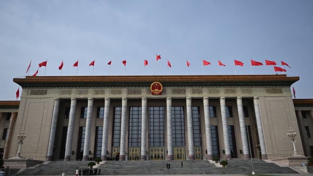 ARCHIV - Auf der Großen Halle des Volkes in Peking wehen rote Fahnen (Archivbild). Foto: Johannes Neudecker/dpa