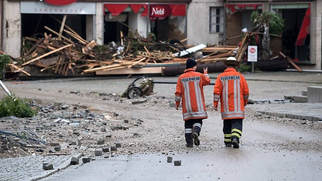 Hochwasser in Niederbayern: Zwei Feuerwehrmänner spazieren am Donnerstag durch die vom Unwetter verwüsteten Strassen von Simbach.