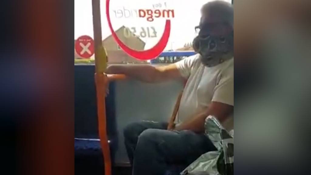 Mann benutzt lebende Schlange als Mundschutz im Bus