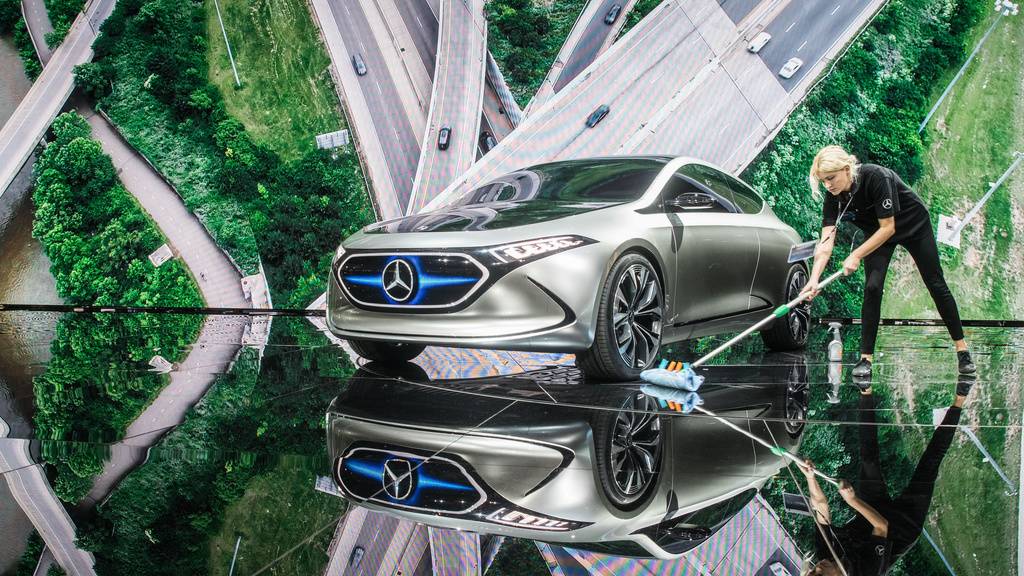 Saubere Sache: Eine Raumpflegerin wischt 2017 an einem Messestand von Mercedes unter einem Elektro-Konzept-Fahrzeug namens EQ A. Das Auto gibt's inzwischen serienmässig. Und Daimler erwägt, bis 2030 alle Modelle CO2-frei zu machen, berichtet ein Fachblatt. (Archivbild)