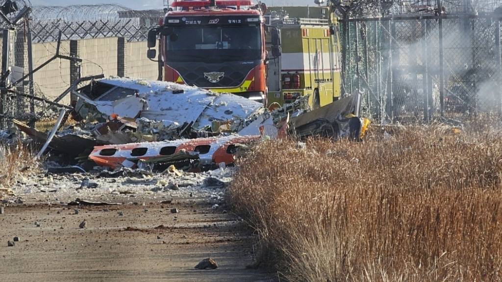 Feuerwehrleute arbeiten daran, einen Brand auf dem internationalen Flughafen Muan zu löschen. Bei der Landung am internationalen Flughafen von Muan in Südkorea ist ein Passagierflugzeug verunglückt. Foto: Maeng Dae-hwan/Newsis/AP/dpa